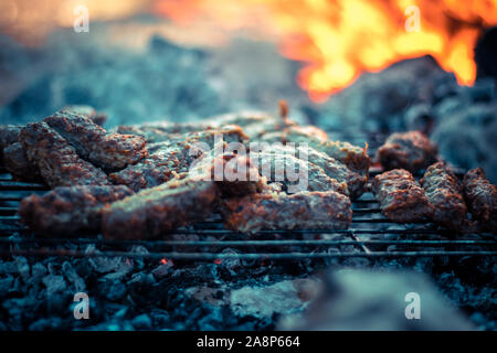 Cuisine balkanique, caévapote de bœuf de porc, caévapocici. Bâtonnets de viande hachés. Griller sur une flamme nue dans la nature Banque D'Images