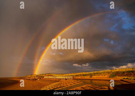Vivid double arc-en-ciel sur la plage de Prestatyn sur la côte nord du Pays de Galles Banque D'Images