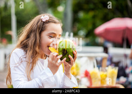 Belle jeune fille à Paseo Bolivar Square dans la ville de Cali en Colombie de manger les fruits tropicaux Banque D'Images