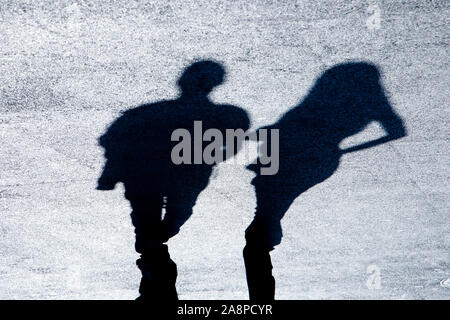 Silhouette d'ombre floue de l'homme et de la femme sur la rue piétonne de la ville en noir et blanc à contraste élevé nuit Banque D'Images