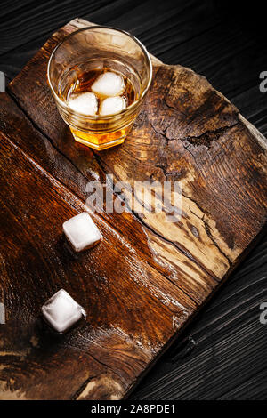 Un verre de boisson alcoolisée à une table en bois. Cocktail de whisky avec de la glace Vue de dessus Banque D'Images