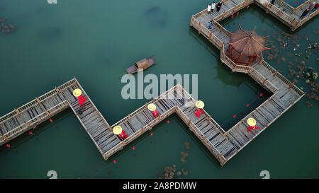 Qian'an. 10 Nov, 2019. Photo aérienne prise le 10 novembre 2019 modèles villageois montre la marche sur le pont sur chevalets en bois d'un parc dans Houtaizi Village de la ville de Qian'an, province de Hebei en Chine du nord. Le gouvernement local a fait de grands efforts pour améliorer le cadre de vie rural cette année. Après la transformation de haut niveau et la construction, une fosse d'élimination des déchets a été transformé en un magnifique parc à l'eau claire et de bâtiments antiques, devenir un lieu public pour les loisirs et le divertissement. Liangkuai Crédit : Jin/Xinhua/Alamy Live News Banque D'Images