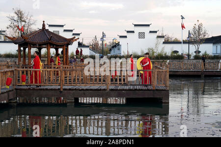 Qian'an, Province du Hebei en Chine. 10 Nov, 2019. Modèles villageois marcher sur le pont à chevalets en bois d'un parc dans Houtaizi Village de la ville de Qian'an, province de Hebei en Chine du nord, le 10 novembre 2019. Le gouvernement local a fait de grands efforts pour améliorer le cadre de vie rural cette année. Après la transformation de haut niveau et la construction, une fosse d'élimination des déchets a été transformé en un magnifique parc à l'eau claire et de bâtiments antiques, devenir un lieu public pour les loisirs et le divertissement. Liangkuai Crédit : Jin/Xinhua/Alamy Live News Banque D'Images