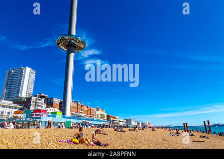 Les gens assis sur la plage avec la tour d'observation Brighton i360 de 162m de haut sur le front de mer, Brighton, Royaume-Uni Banque D'Images