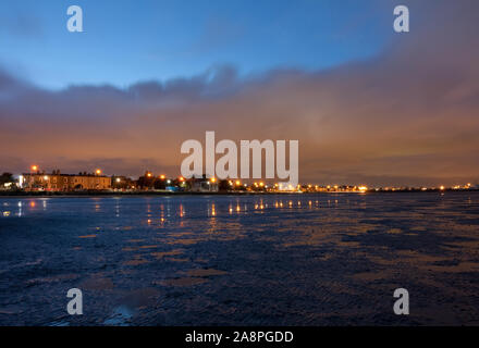 Lumières lointaines avec effets starburst Sandymount Strand le long, Dublin, Irlande. Le coucher du soleil, lumière, crépuscule, marée basse, marée basse, la plage de Sandymount Banque D'Images