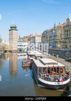 Prague, République tchèque, le 22 mars 2019 : : Restaurant dans un bateau sur la Vltava, et une vieille tour en brique, vue du remblai à Prague Banque D'Images