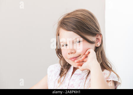 Smiling little woman, close-up face portrait sur fond de mur gris Banque D'Images