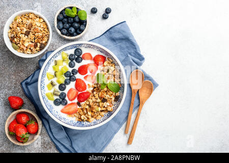 Bol de yogourt petit-déjeuner avec des céréales, baies et fruits. Vue de dessus de table. Nettoyer, manger la nourriture végétarienne saine notion Banque D'Images