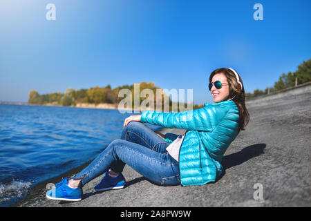 Heureux femme joyeuse d'écouter de la musique tout en étant à l'extérieur. Music concept. Banque D'Images