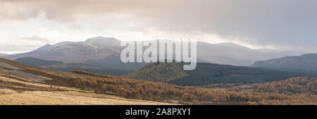 Il y a une mince couche de neige sur Lochnagar a la fin de l'automne, mais les bouleaux dans Glen Feardar encore conserver leur feuillage d'automne Banque D'Images