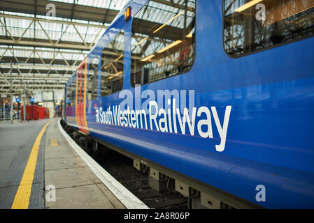 Un bleu et rouge South Western Railway train en attente d'écarter la plate-forme à la gare de Waterloo à Londres. Banque D'Images