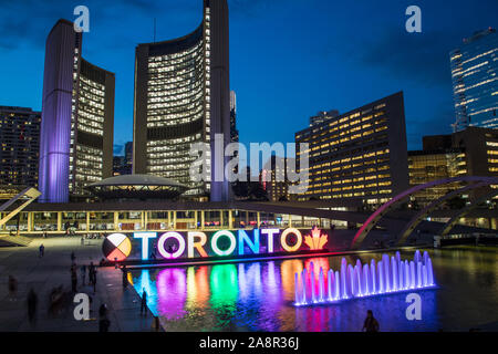 TORONTO, CANADA - 17 JUIN 2019 JUILLET : le signe de Toronto au Nathan Phillips Square avec la Mairie et d'autres l'architecture dans l'arrière-plan. Prise à nig Banque D'Images