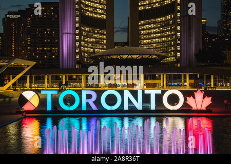 TORONTO, CANADA - 17 JUIN 2019 JUILLET : un gros plan de l'inscription de Toronto au Nathan Phillips Square de l'Hôtel de ville en arrière-plan. Prises de nuit. Les gens Banque D'Images