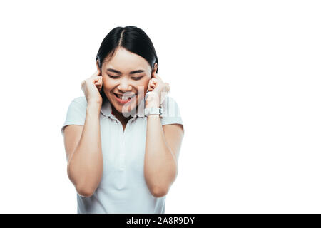 Happy attractive asian girl mettre les doigts dans les oreilles isolated on white Banque D'Images