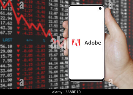 Logo de l'entreprise Adobe Systems Inc affiché sur un smartphone. Contexte du marché boursier négatif. Credit : PIXDUCE Banque D'Images