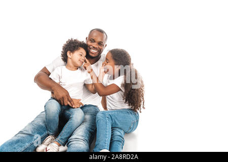 Cheerful african american frère et sœur de toucher le nez de l'autre tout en étant assis avec papa sur fond blanc Banque D'Images