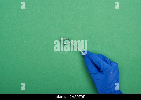 Portrait de dentiste dans le latex glove holding dental mirror isolé sur green Banque D'Images
