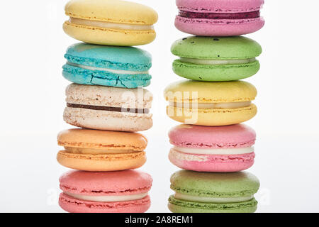 Rangées de délicieux macarons français colorés de différentes saveurs isolated on white Banque D'Images