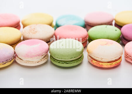 Macarons sucrés français colorés de différentes saveurs sur fond blanc Banque D'Images