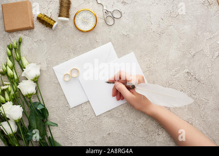 Portrait de femme écrit sur une carte vide près de mariage, compas, ciseaux, canettes et eustoma fleurs sur la surface texturée Banque D'Images