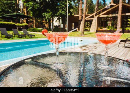 Verres à Cocktail avec alcool cocktails sur la table proche piscine Banque D'Images