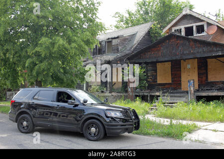 Véhicule de police de Detroit à l'extérieur des immeubles en ruines, Detroit, Michigan, USA Banque D'Images