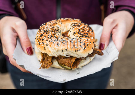 Bagel au pastrami avec la viande bovine et des cornichons dans un marché de l'alimentation de rue. Banque D'Images