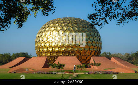 Un groundsman tend une zone en face de la mère ou du Matrimandir Temple, qui se dresse comme le centre spirituel,créé par la mère de la Sri Aur Banque D'Images