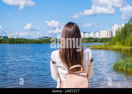 Fille brune avec un sac à dos offre une vue panoramique. Lac et paysage magnifique. L'aventure, la liberté, le mode de vie Banque D'Images