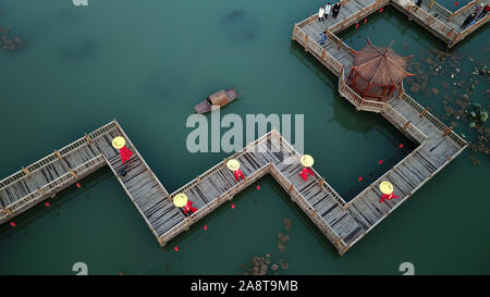 Beijing, Chine. 10 Nov, 2019. Photo aérienne prise le 10 novembre 2019 modèles villageois montre la marche sur le pont sur chevalets en bois d'un parc dans Houtaizi Village de la ville de Qian'an, province de Hebei en Chine du nord. Le gouvernement local a fait de grands efforts pour améliorer le cadre de vie rural cette année. Après la transformation de haut niveau et la construction, une fosse d'élimination des déchets a été transformé en un magnifique parc à l'eau claire et de bâtiments antiques, devenir un lieu public pour les loisirs et le divertissement. Liangkuai Crédit : Jin/Xinhua/Alamy Live News Banque D'Images