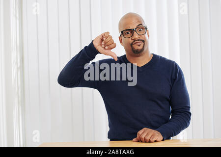 Malheureux homme d'âge moyen faire drôle de visage et showing thumbs-vers le bas Banque D'Images