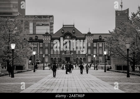 DEC 6, 2019 Tokyo, Japon - Tokyo Station old heritage building Marunouchi district avec tour de bureau moderne en soirée et les peuples sur place de la gare. Banque D'Images