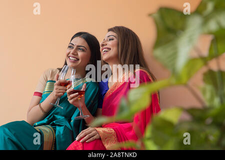 Les femmes en saree boire un verre ensemble Banque D'Images