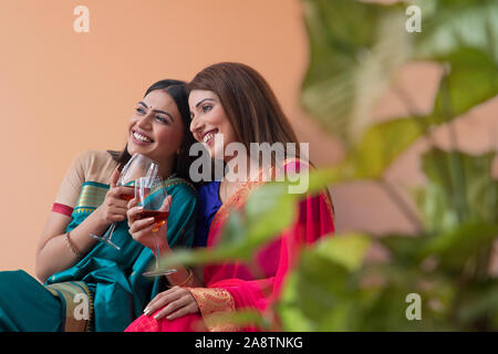 Les femmes en saree boire un verre ensemble Banque D'Images