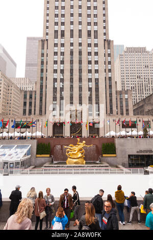 Statue de Prométhée dans la basse Plaza avec vue sur la patinoire, du Rockefeller Center, Manhattan, New York City, États-Unis d'Amérique. Banque D'Images