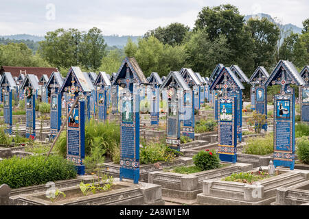 Des croix en bois sculptées et peintes dans le célèbre cimetière joyeux du village de Săpânța, Maramureş, Roumanie Banque D'Images