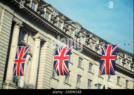 Union Jack flag décorations suspendus au-dessus des rues de Londres, Royaume-Uni, sous le ciel bleu doux Banque D'Images