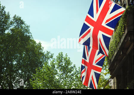 Union Jack flag décorations suspendus au-dessus des rues de Londres, Royaume-Uni, sous le ciel bleu doux Banque D'Images