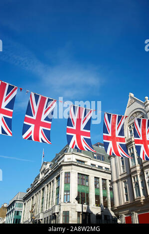 Union Jack flag décorations suspendus au-dessus des rues de Londres, UK contre ciel bleu Banque D'Images