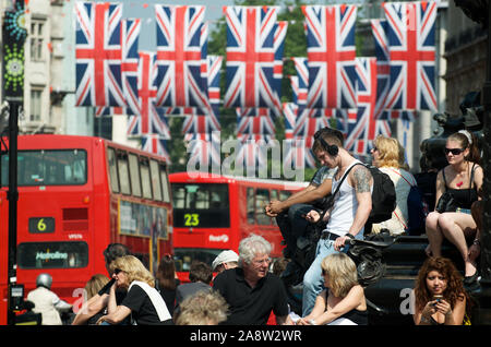 Londres - le 24 mai 2012 : les piétons et des autobus à impériale rouge bloquer une rue animée décorée de drapeaux Union Jack britannique dans Piccadilly Circus. Banque D'Images