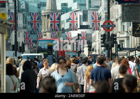 Londres - le 24 mai 2012 : les piétons et le trafic d'encrasser une rue animée décorée de drapeaux Union Jack britannique dans le centre de Londres. Banque D'Images