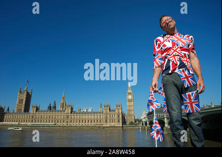 L'homme confus par Brexit méconnaissables enchevêtrés permanent dans la région de Union Jack flag bunting en face de la ville de Londres à Westminster Banque D'Images