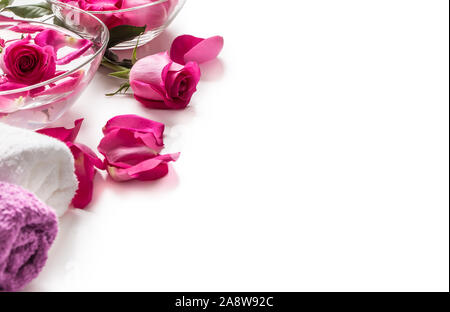 Pétales de roses roses dans un bol avec des serviettes et de l'eau pure plus blanc.. Concept de bien-être et spa Banque D'Images