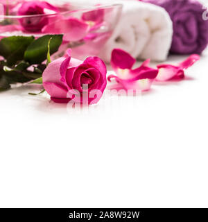Pétales de roses roses dans un bol avec des serviettes et de l'eau pure plus blanc.. Concept de bien-être et spa Banque D'Images