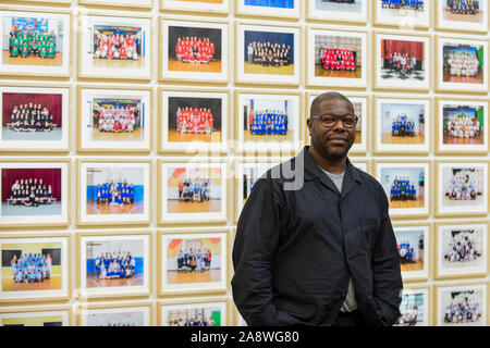 Londres, Royaume-Uni. 11 novembre 2019. Turner Prize-winning artiste et cinéaste oscarisé Steve McQueen pose à l'aperçu de l'Année '3', sa nouvelle exposition à la Tate Britain. L'œuvre se compose de 3 128 photographies de classe à l'école traditionnelle de l'année 3 élèves de 1 504 écoles primaires de Londres. Le travail reflète une image du présent et est à l'affiche 12 novembre au 3 mai 2020. Crédit : Stephen Chung / Alamy Live News Banque D'Images