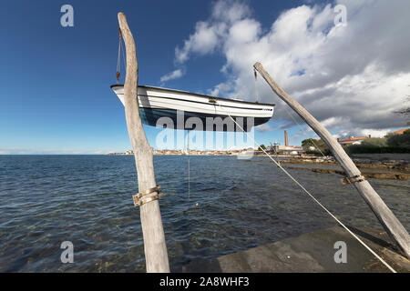 Bateau suspendu sur la plage en face de la ville d'Umag, Istrie, Croatie Banque D'Images