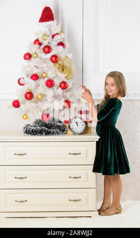 Célébration de Noël. Obtenir incroyablement excité à propos de noël. Fille de l'arbre de Noël pour enfants près de minuit réveil d'attente. Dernières préparations. Enfant célébrer Noël à la maison. Jour préféré de l'année. Banque D'Images