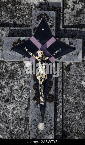 Close up on old weathered pierre tombale et crucifix dans un cimetière Banque D'Images