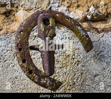 Old rusty horse shoe accroché sur un mur extérieur en milieu rural France Banque D'Images