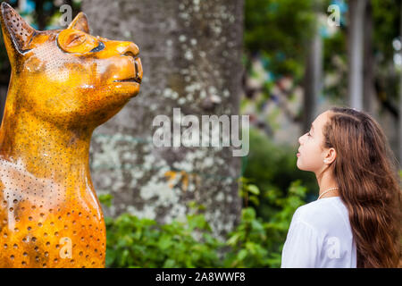 CALI, COLOMBIE - Octobre 2019 : Jeune fille touriste en visite le célèbre chat statues faites par différents artistes de la ville de Cali en Colombie Banque D'Images